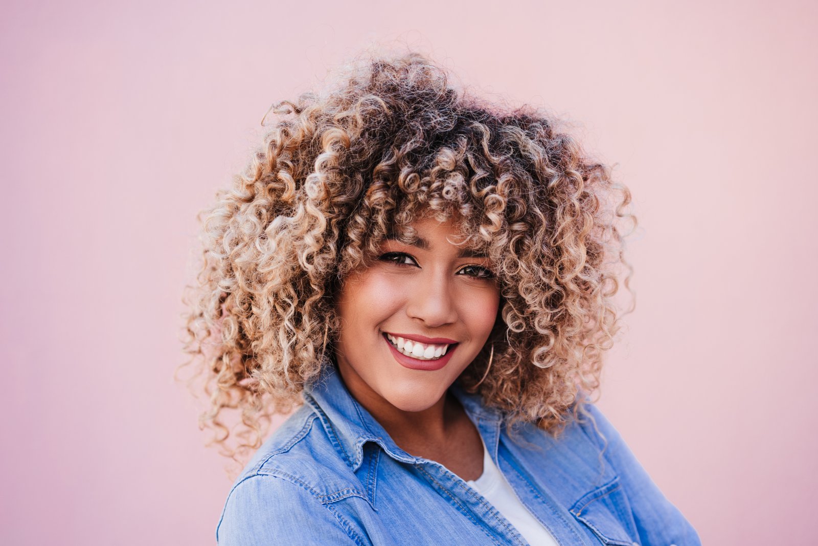 Fryzury ochronne dla włosów kręconych i afro 1 portrait of smiling hispanic woman with afro hair 2024 11 02 23 48 21 utc